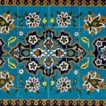 eine blau-gelbe Fliese mit Blumen darauf